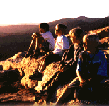 Teenagers sitting on the rocks near the lake